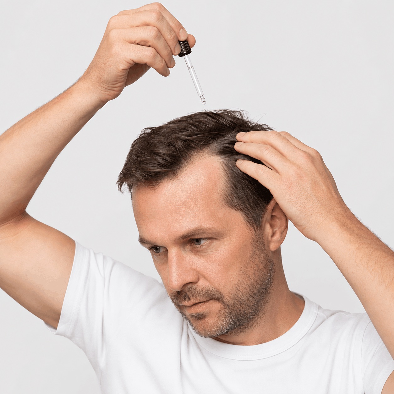 Bărbat care aplică serul cu picurătorul direct pe scalp